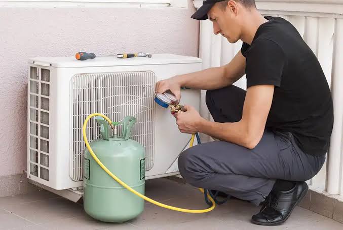 Technician checking a compact outdoor air conditioning system